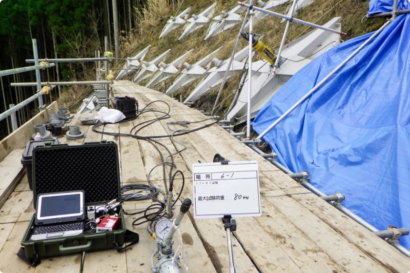 法面補強工事におけるアンカー引張試験の測定機器と作業現場