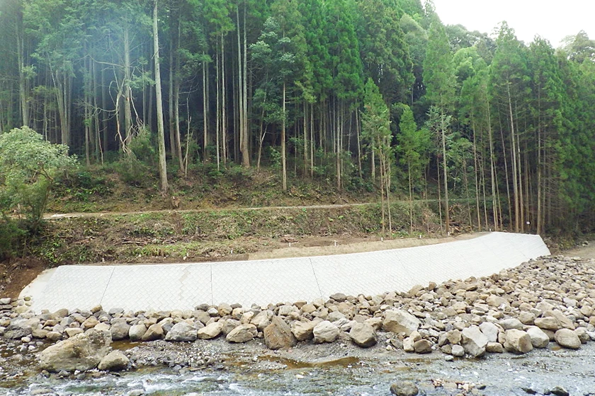 河川沿いに設置されたコンクリートブロックの護岸工事完成風景