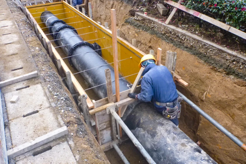 地中に設置された大口径水道管を固定する作業員